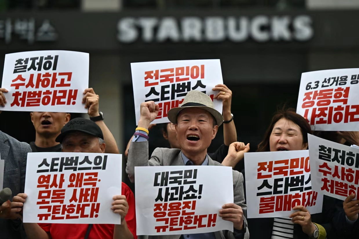 Người biểu tình Hàn Quốc cầm các biểu ngữ phản đối Starbucks
